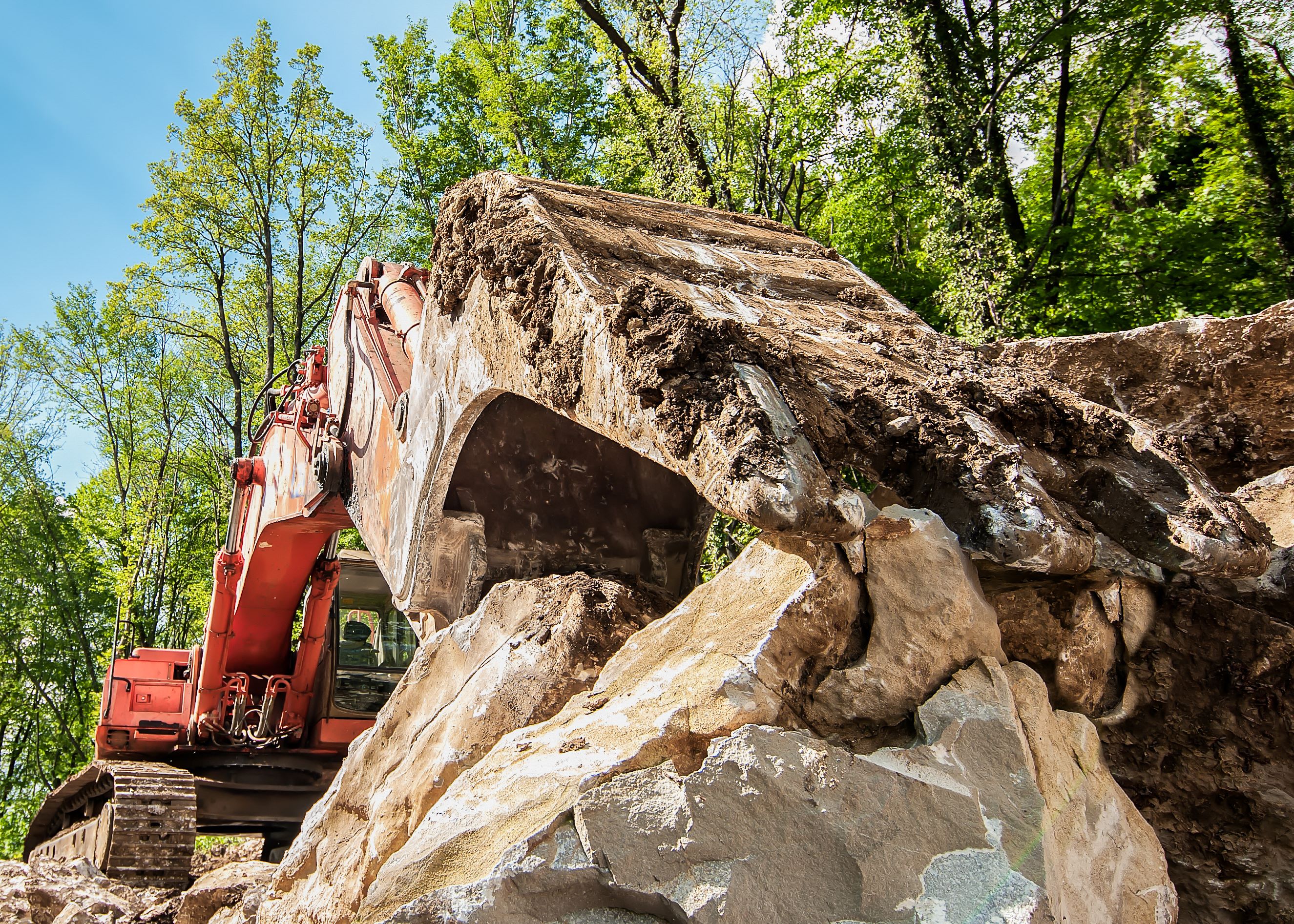 Hydraulic breaker attachment fracturing bedrock for removal